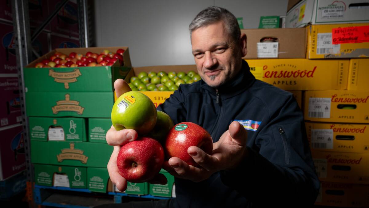 Derek Stamatis, one of the owners of Regional Wholesale Fruit Markets with stickered apples. Picture by Elesa Kurtz