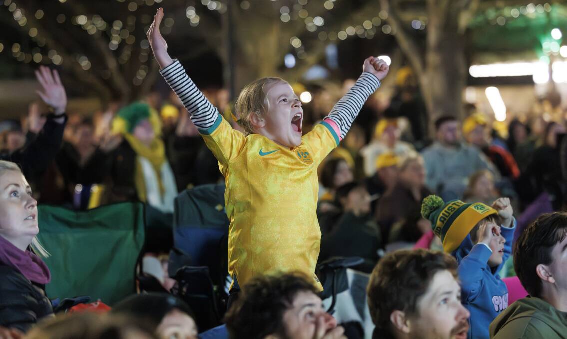 Matildas fan Addison Irvine, 7, cheers on the green and golds at the Canberra live site in Garema Place. Picture by Keegan Carroll