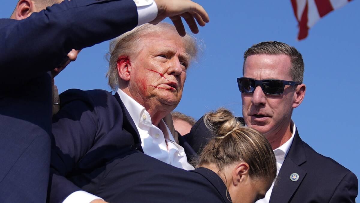 Republican presidential candidate former president Donald Trump is surrounded by US Secret Service agents as he leaves the stage at a campaign rally on July 13. Picture AP