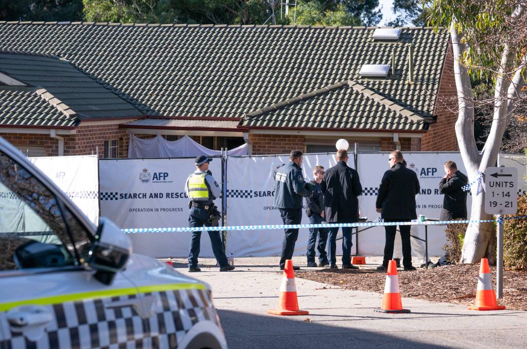 Detectives gather outside the Gordon home on Sunday where the alleged murder took place. Picture by Sitthixay Ditthavong 
