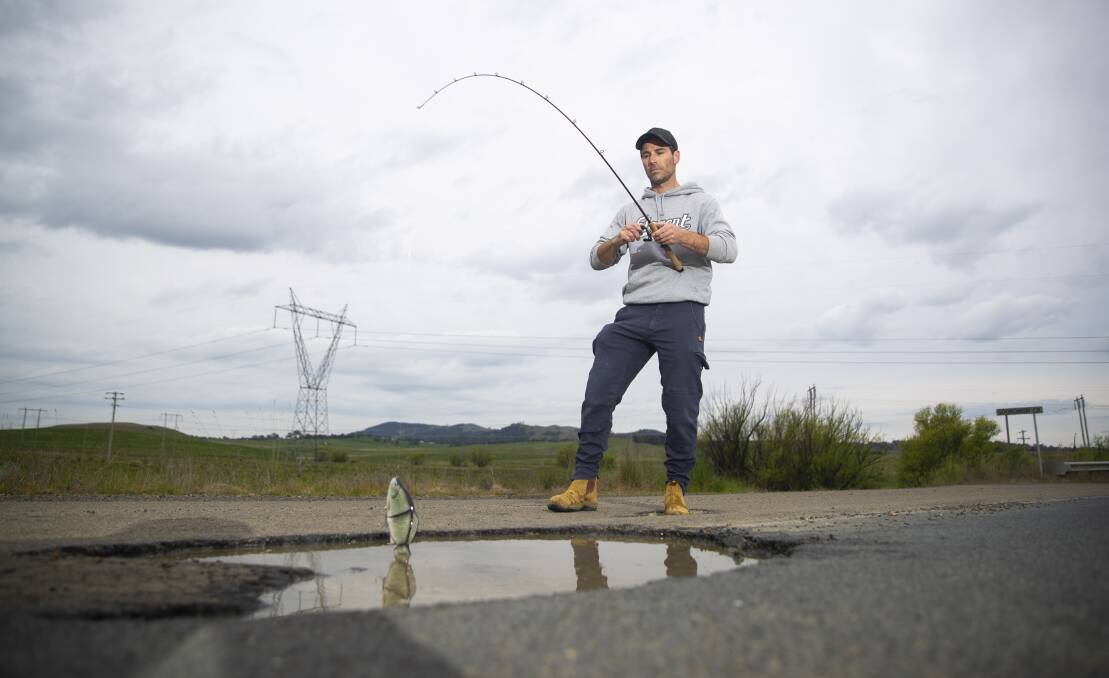 Back in December last year, Ben Wilkie of Fraser took to fishing in a huge Canberra pothole. Picture by Keegan Carroll 
