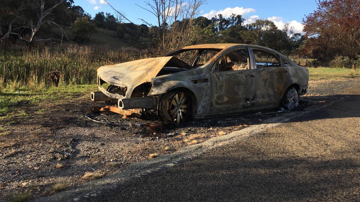 A burnt out stolen car on the Old Federal Highway just outside Canberra. Picture: Peter Brewer