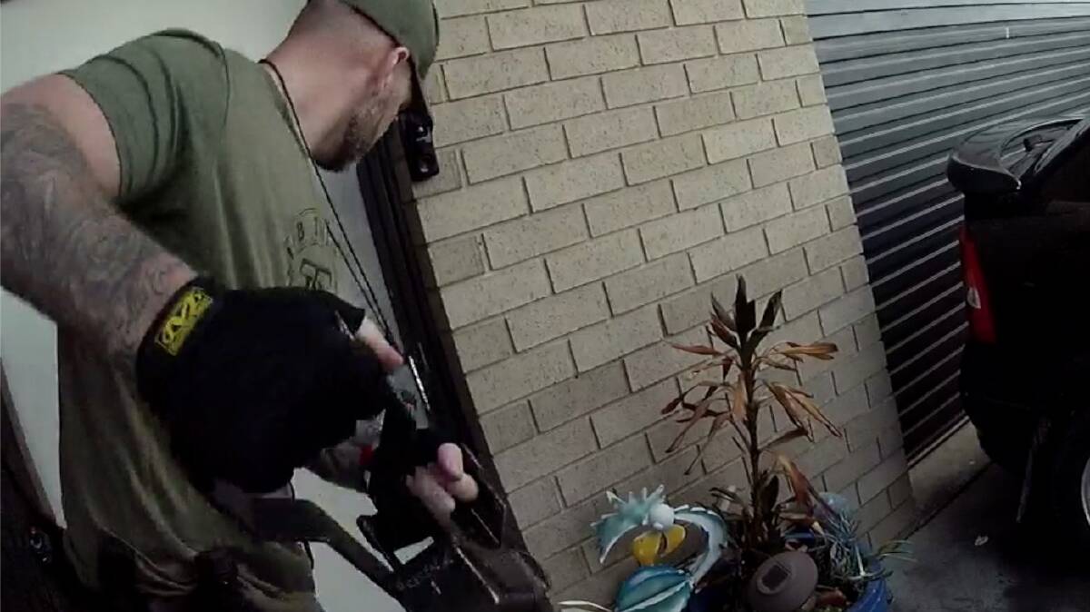 A police officer assigned to Operation Toric uses a door ram to force entry into a suspect's home. Picture supplied 