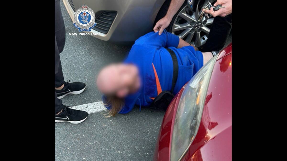 The alleged offender handcuffed and on the ground in the Fyshwick carpark. Picture supplied 