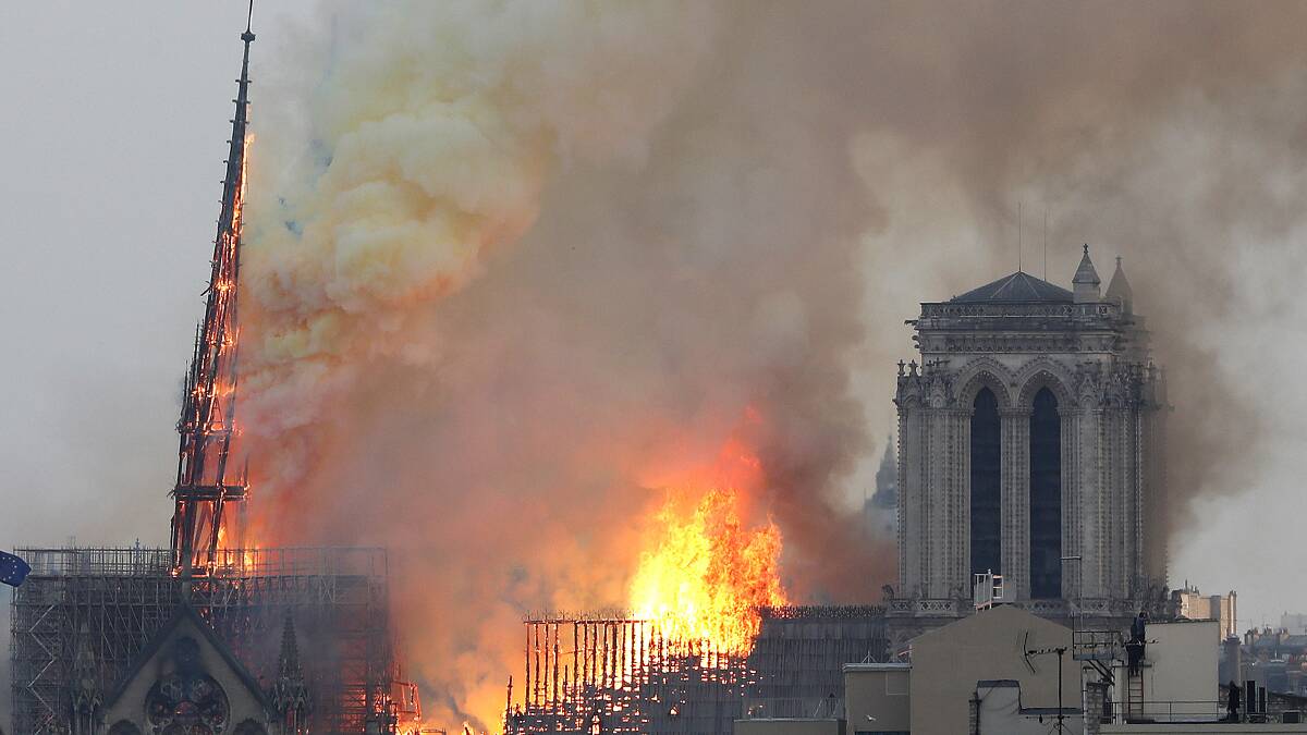 Massive plumes of yellow brown smoke is filling the air above Notre Dame Cathedral and ash is falling on tourists and others around the island that marks the center of Paris. Photo: AP