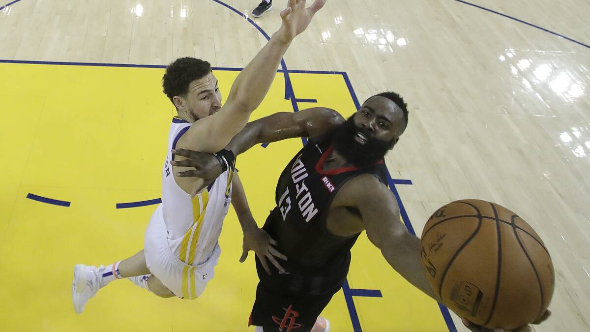 Houston Rockets guard James Harden, right, shoots against Golden State Warriors guard Klay Thompson during game 1 on Monday. Photo: AAP