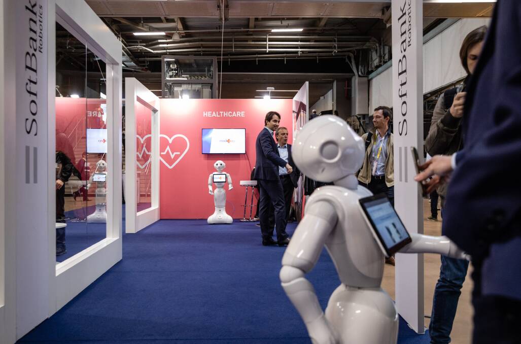 Attendees interact with a Pepper humanoid robot at the Viva Technology conference in Paris. Donald Trump's latest offensive against Huawei puts Europe in an even bigger bind over which side to pick. Picture: Marlene Awaad/Bloomberg