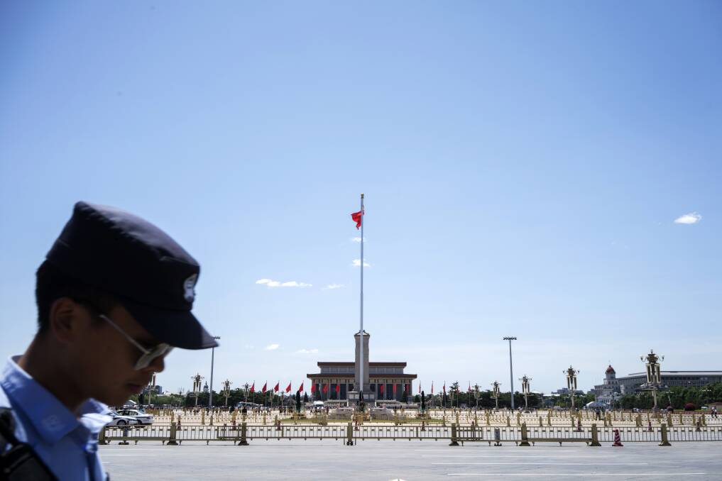 A police officer walks past the Monument to the People's Heroes and the Mausoleum of Mao Zedong at Tiananmen Square in Beijing, China. Picture: Bloomberg