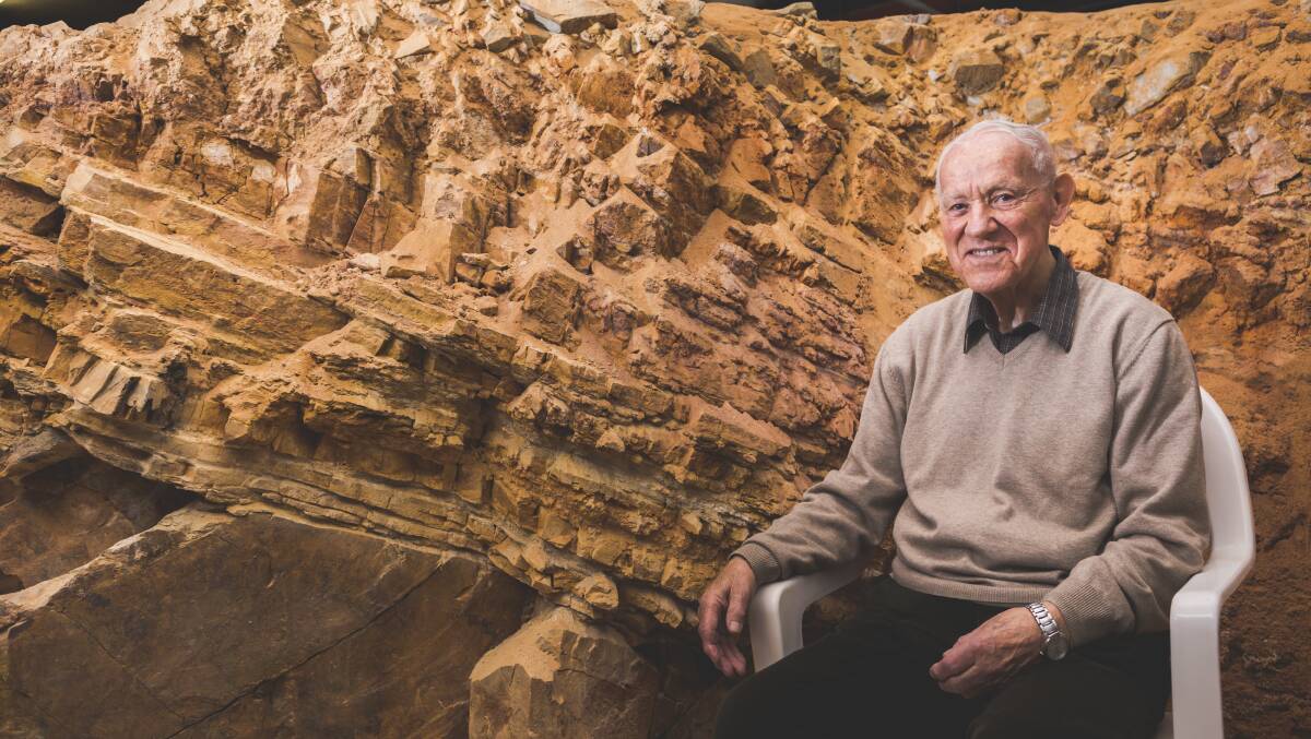 Renowned geologist Wolf Mayer will be running a tour underneath Parliament House. Wolf Mayer sitting next to two rock masses, 10 million years apart joined, called an unconformity. Picture: Jamila Toderas
