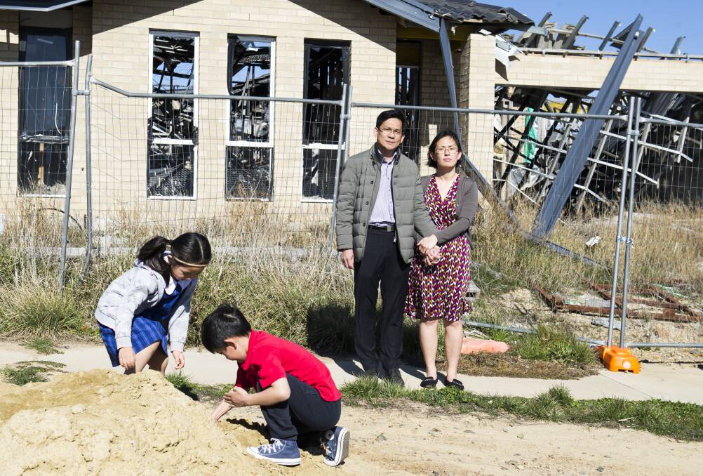 Dat Vo and his wife, Judy, with Yuha (5) and Minhha (7) outside their gutted half-built home. Picture: Dion Georgopoulos.