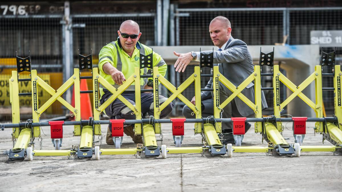 ACT Roads works co-ordinator Mick Sullivan and Bren Burkevics from the Justice and Community Safety Directorate check out the new portable barriers the ACT government has bought to stop vehicle-ramming attacks. Picture: Karleen Minney