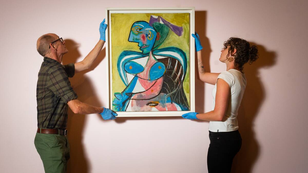 Exhibition Istllers, Ben Taylor and Ruby Rossiter hang Pablo Picasso's L'Arlesienne: Lee Miller painting for the Matisse Picasso exhibition at the National Gallery of Australia. Picture: Elesa Kurtz