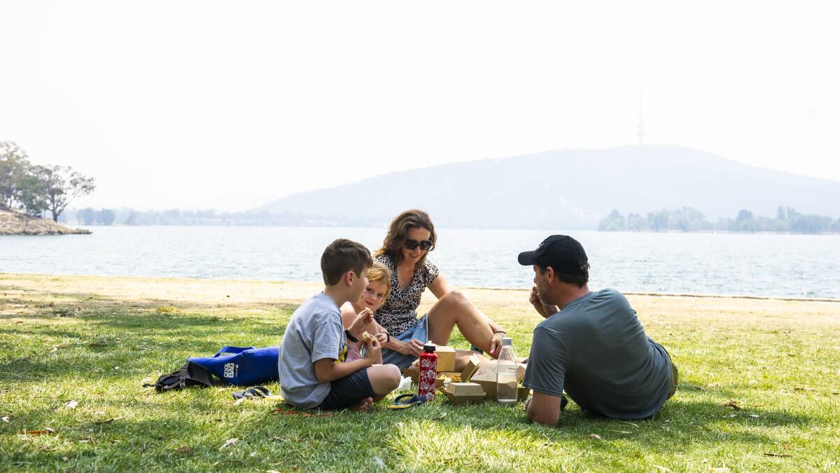 The Brooks family brave the heat and enjoy a picnic outside the Canberra Yacht Club. Picture: Dion Georgopoulos
