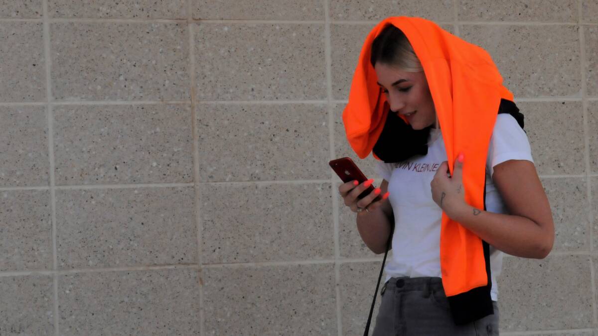 Jasmin Parker, 19, leaves court on Tuesday with a high-vis shirt that she had earlier used to shield her face from the camera. Picture: Blake Foden