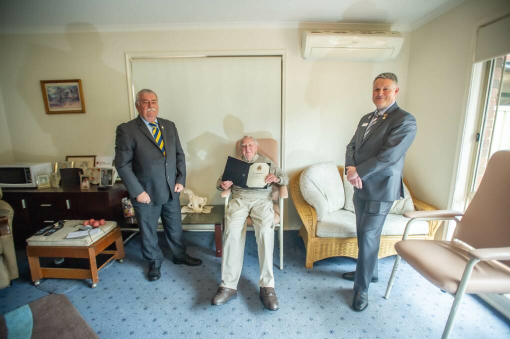 RSL ACT branch president John King (left) and Gungahlin sub-branch president Shaun McGill (right) present Mr Murphy with a certificate in recognition of his 100th birthday. Picture: Karleen Minney