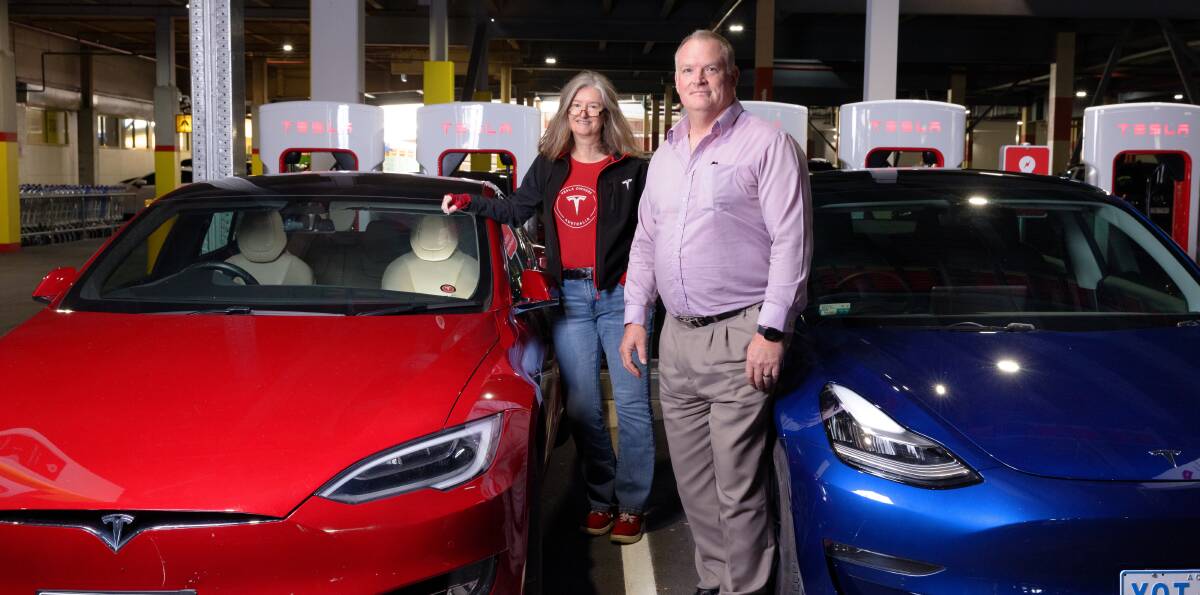Jude Burger and Ross Hetherington fill up at the new Tesla supercharger station at South Point Shopping Centre in Tuggeranong. Picture by Sitthixay Ditthavong