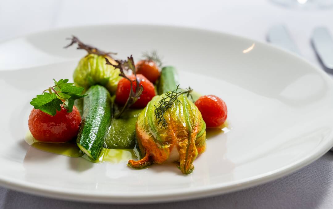 Zucchini flower stuffed with scallop and crab mousse with a basil emulsion and confit cherry tomato. Picture by Elesa Kurtz