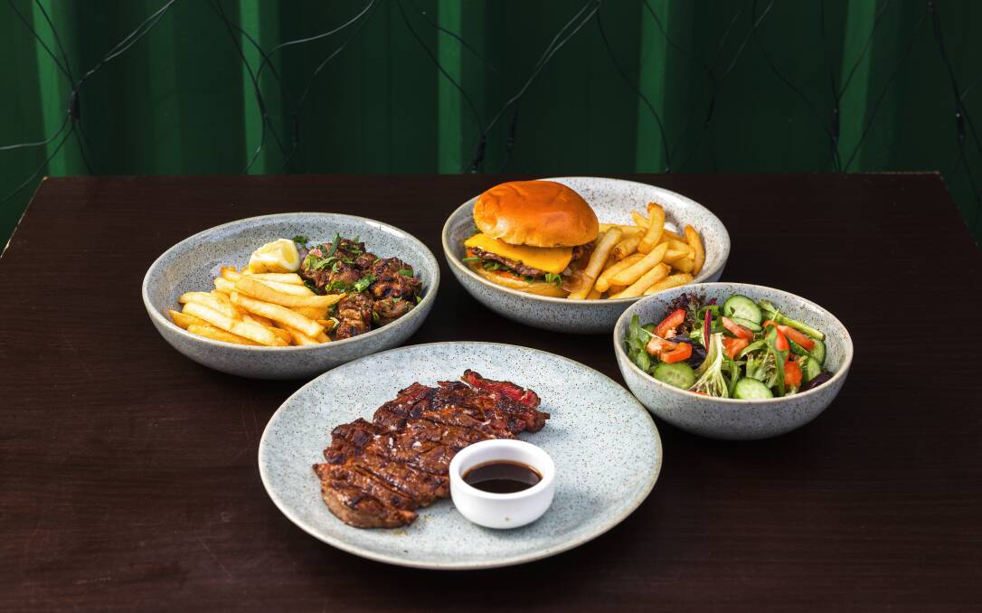 Moowing Steak's cumin-marinated boneless lamb shoulder, grass-fed rib eye, grilled rib eye steak burger, and garden salad. Picture by Sitthixay Ditthavong