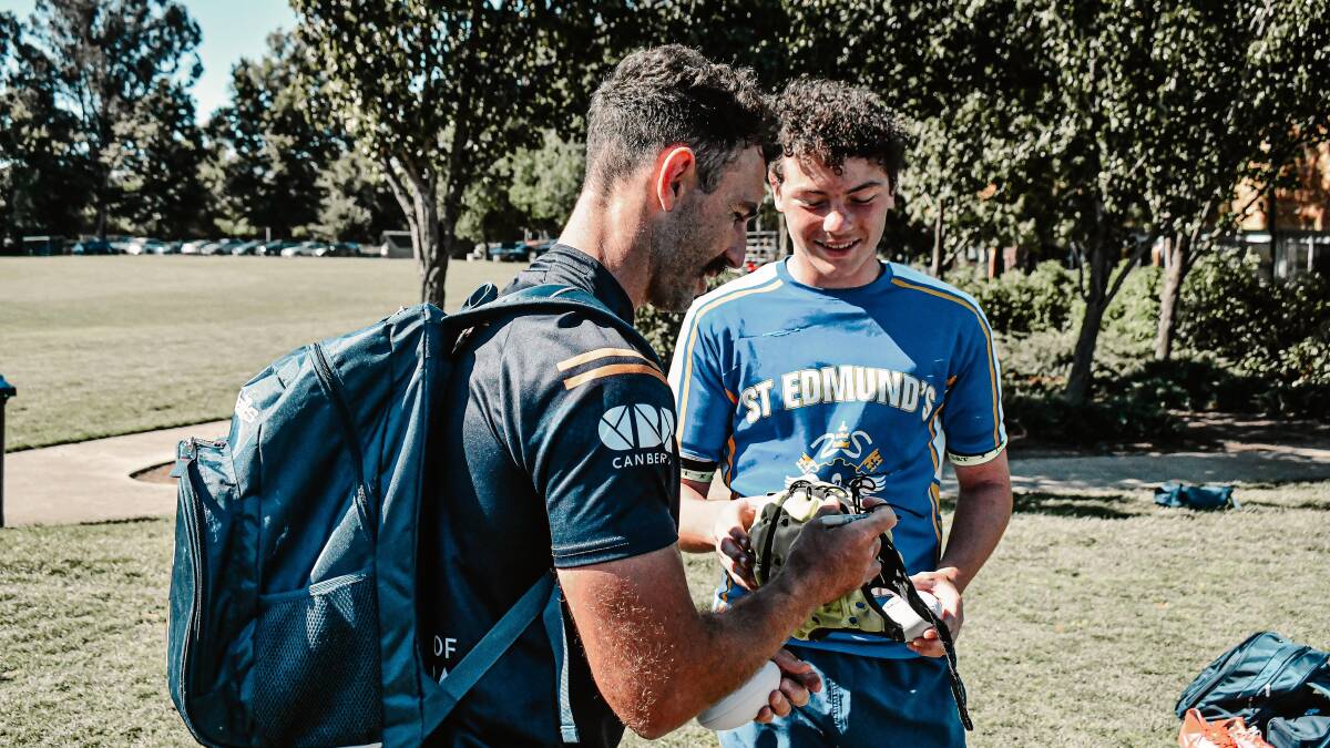 Nic White signs a pair of boots for a St Edmund's College student. Picture by Lachlan Lawson