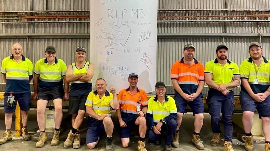 Gippsland's Opal Australian Paper mill workers gather around the last roll of paper to come out of the machine on December 23. Picture supplied