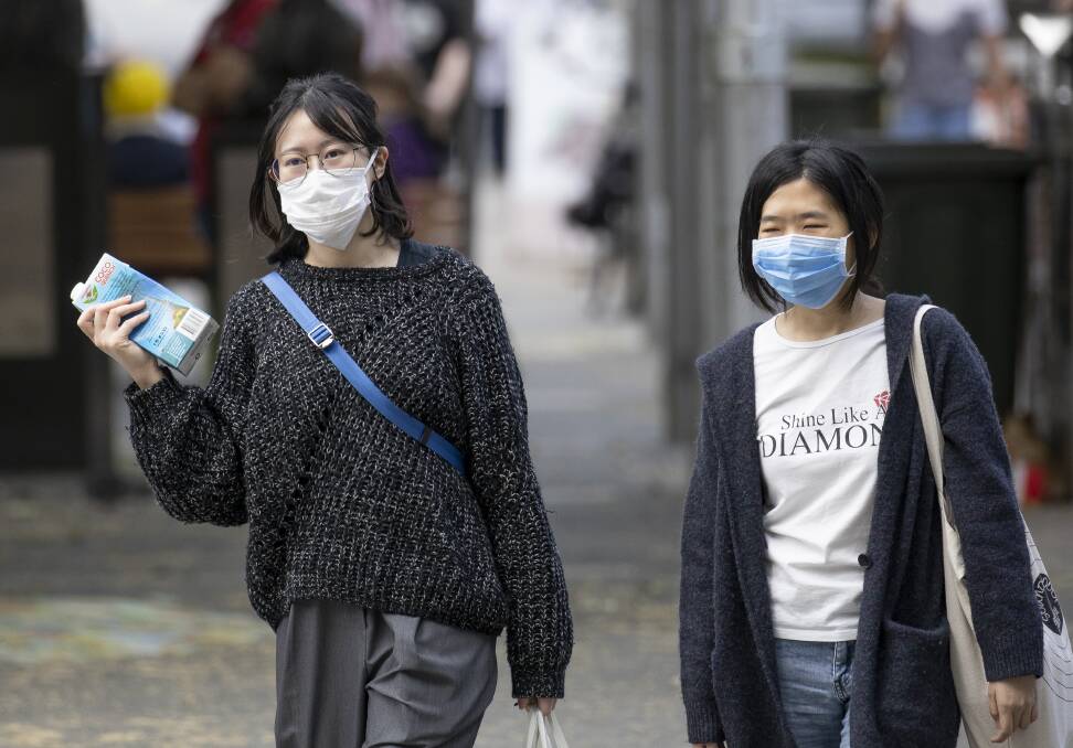 Two women walk through Garema Place wearing face masks. Picture: Sitthixay Ditthavong