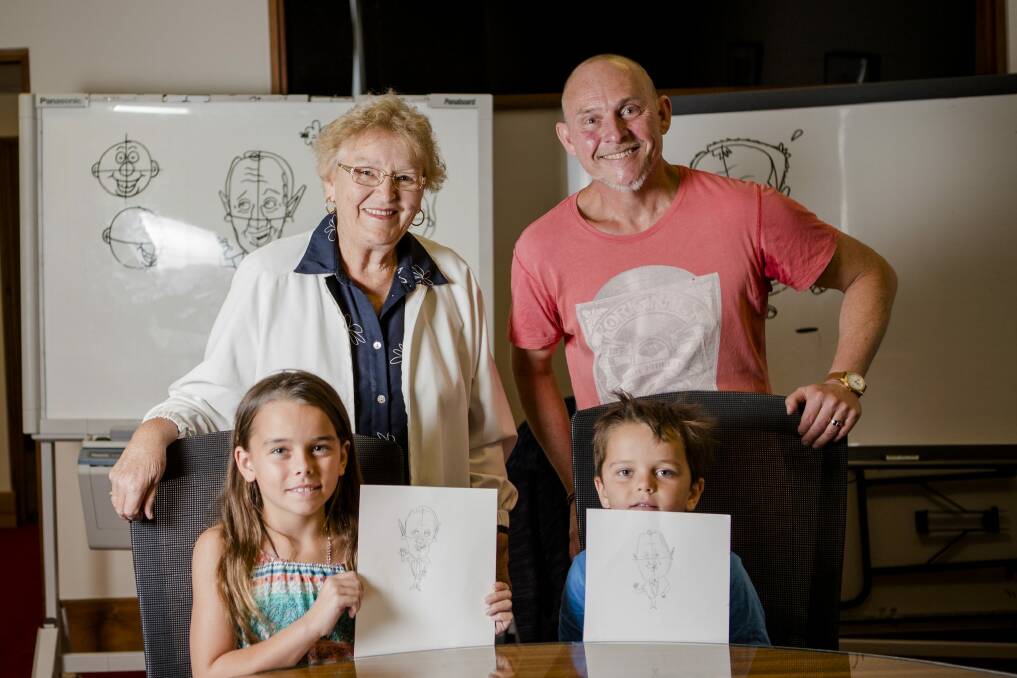 Colleen Kennedy, of Jervis Bay, and her grandchildren Caitlin Isbel, 9, and Thomas Isbel, 6, of Duffy, with Andrew Hore after taking part in his Cartooning Masterclass at Old Parliament House.  Photo: Jamila Toderas