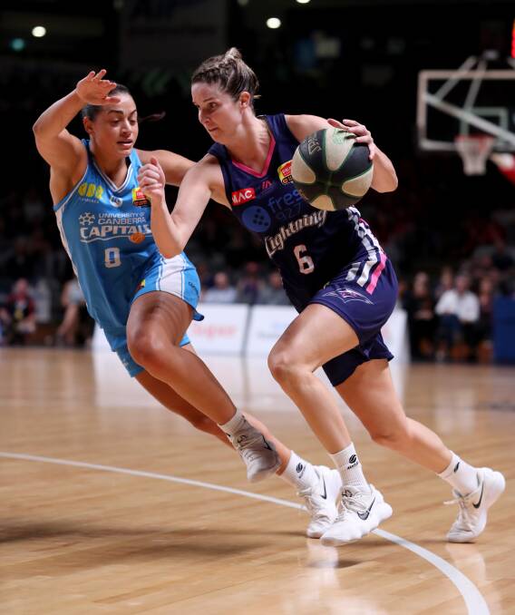 Abby Cubillo of the Capitals and Stephanie Bilcavs of the Lightning during game two of the WNBL grand final series. The series is coming back to Canberra for the decider on Saturday. Photo: AAP