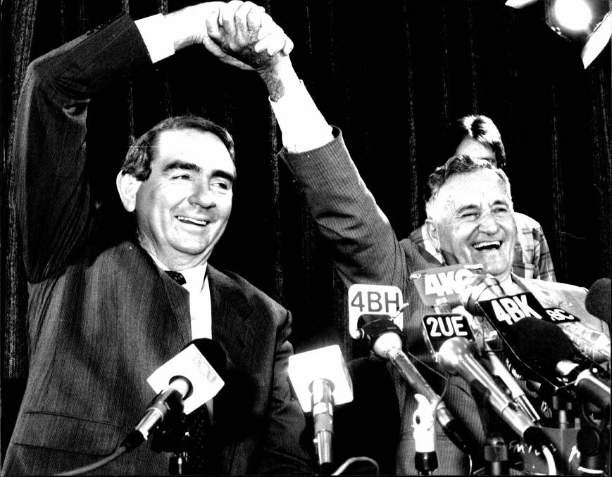 Mike Ahern and his deputy Bill Gunn give a victory salute in Mr Ahern's first press conference as premier. Photo: Fairfax Archives