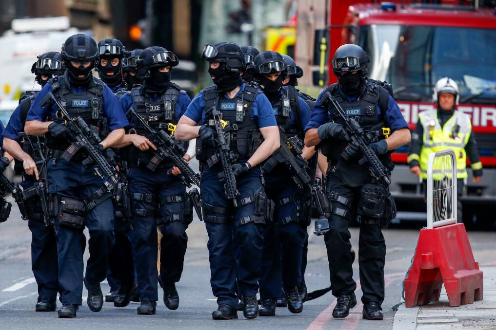 Armed police officers patrol streets near the scene of the terror attack in London. Photo: Bloomberg