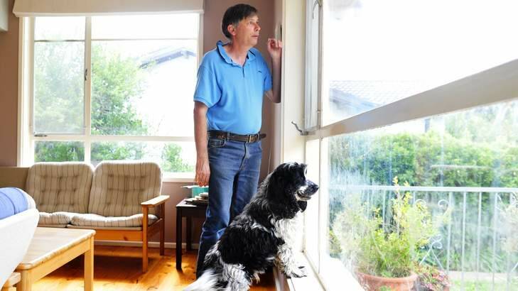 THE DANGER WITHIN: Tim Lyon and his dog, Max, at their Pearce home, which contains loose amosite asbestos. Photo: Melissa Adams