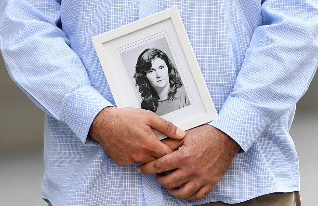 A family member holds a picture of murder victim Patricia Riggs outside the Supreme Court in Brisbane on Thursday. Photo: AAP
