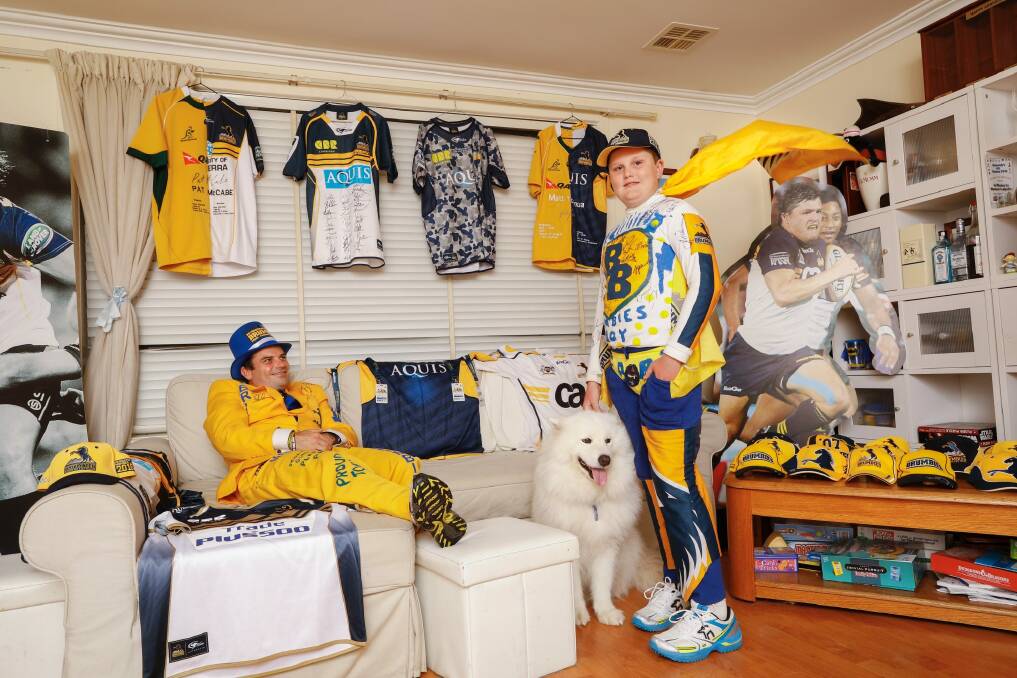 Trevor and Josh Hancock aka Brumbies Man and Brumbies Boy, at home with their dog Neo and part of their extensive Brumbies memorabilia collection Photo: Sitthixay Ditthavong