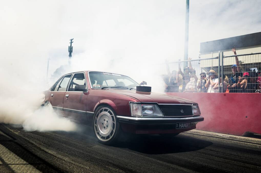 A Commodore smokes its tyres on Skid Row inside Summernats Photo: Dion Georgopoulos