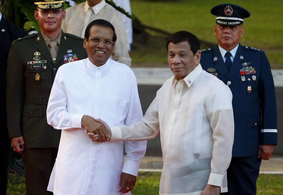 Like-minded: Sri Lanka President Maithripala Sirisena, left, and Philippine President Rodrigo Duterte shake hands in Manila last month. Photo: AP