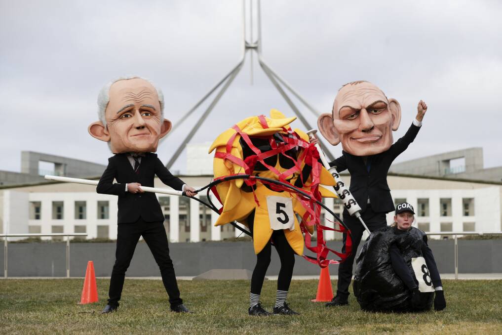 Puppets of Malcolm Turnbull and Tony Abbott rig the sun versus coal race in a protest outside Parliament on June 26, 2018. Photo: Alex Ellinghausen