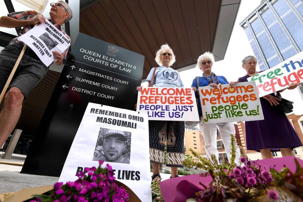 Placards are held at a vigil outside the Brisbane Magistrates Court on Monday. Photo: AAP