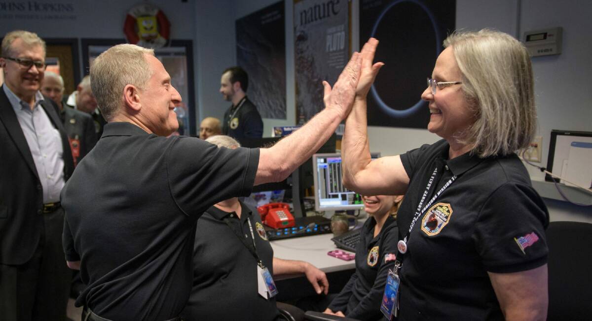New Horizons principal investigator Alan Stern, left, high fives mission operations manager Alice Bowman after the team received signals from the spacecraft that it collected data about 4 billion miles from Earth.  Photo: BILL INGALLS