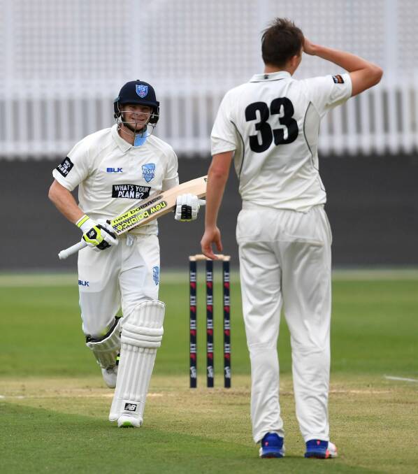 Cheshire grin: Steve Smith smiles at bowler Simon Mackin after clearing the field. Photo: AAP