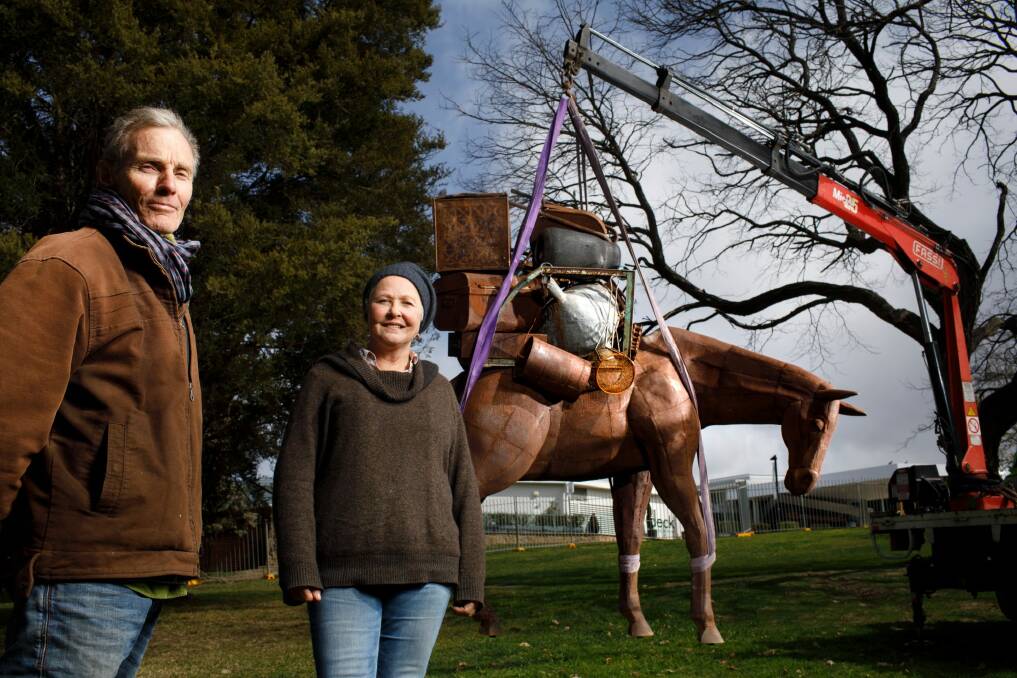 Artists Andy Townsend, left, and Suzie Bleach at the installation of their sculpture "A Burden" in Commonwealth Park. Photo: Sitthixay Ditthavong
