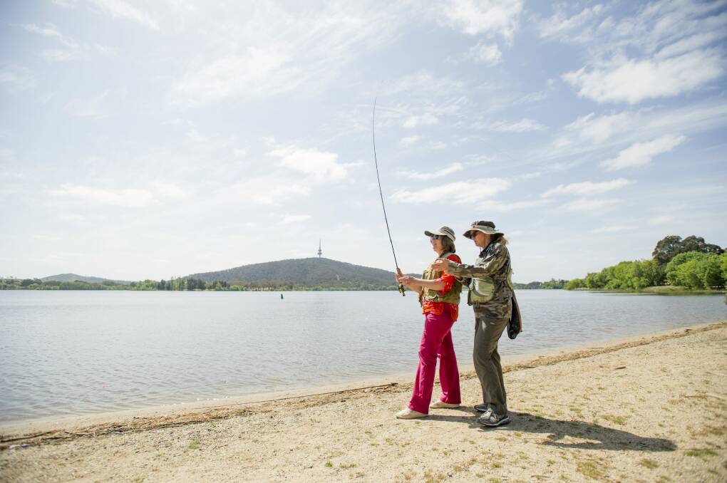 Kerryn Milligan (left) shows Bernadette Bradley how to flyfish on the shore of Lake Burley Griffin.
 Photo: Jay Cronan