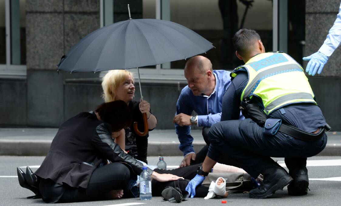 Bystanders comforted the injured in Bourke Street. Photo: Justin McManus