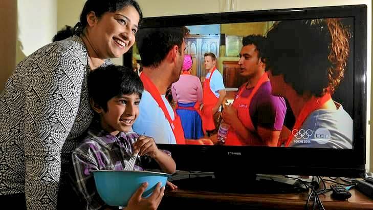 <i>MasterChef</i> contestant, Rishi Desai (on screen with purple shirt). Watching an episode from their home in Queanbeyan is Rishi's wife Mitra and six-year-old son Sharang. Photo: Graham Tidy