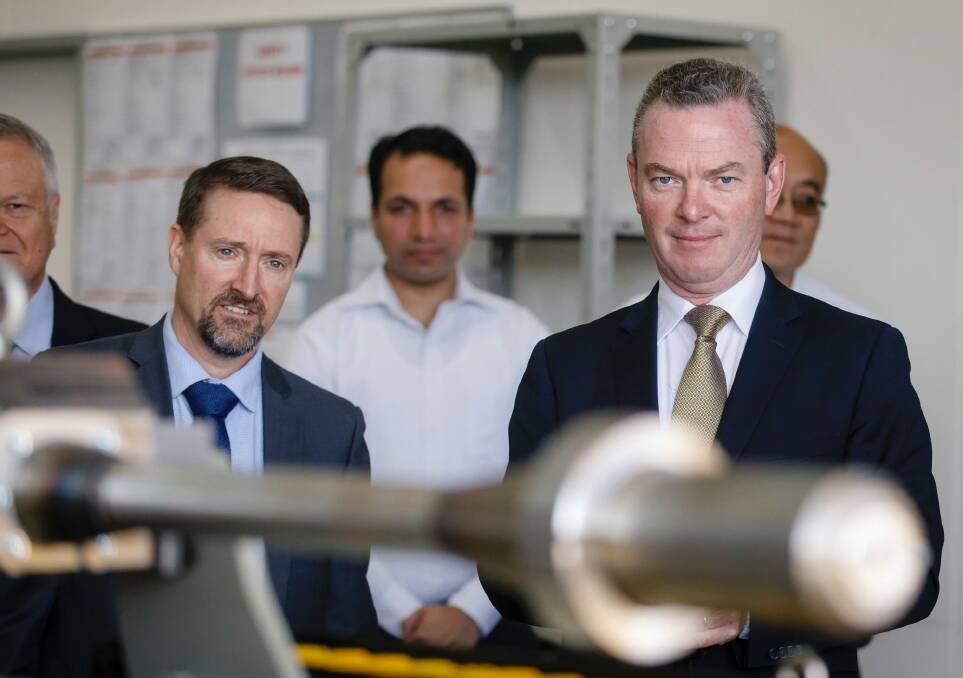 Defence Industry Minister Christopher Pyne takes the controls while touring a new Electro Optic Systems  facility in Hume on Tuesday. Photo: Sitthixay Ditthavong