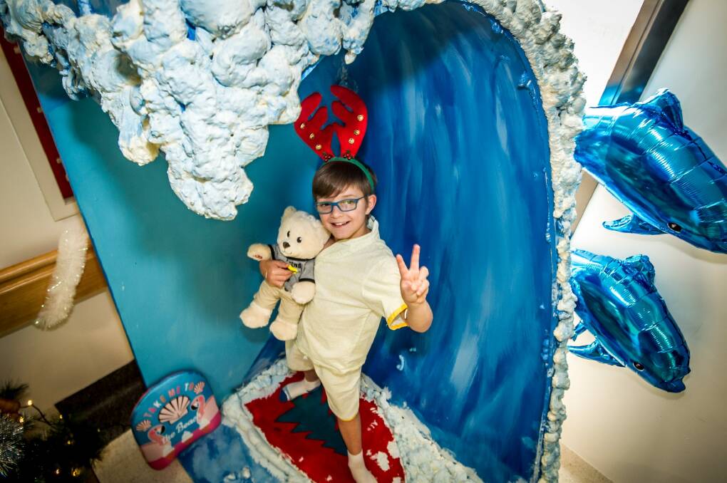 Patient Ronin Smith, 9, in hospital recovering from meningitis, plays with his teddy among the ward decorations. Photo: Karleen Minney
