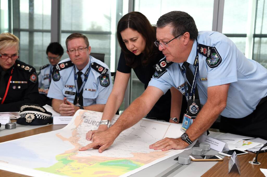 Queensland Premier Annastacia Palaszczuk (centre) is briefed by Police Commissioner Ian Stewart (right) on the floods situation in the state's north at the State Emergency Complex in Brisbane. Photo: Dan Peled.