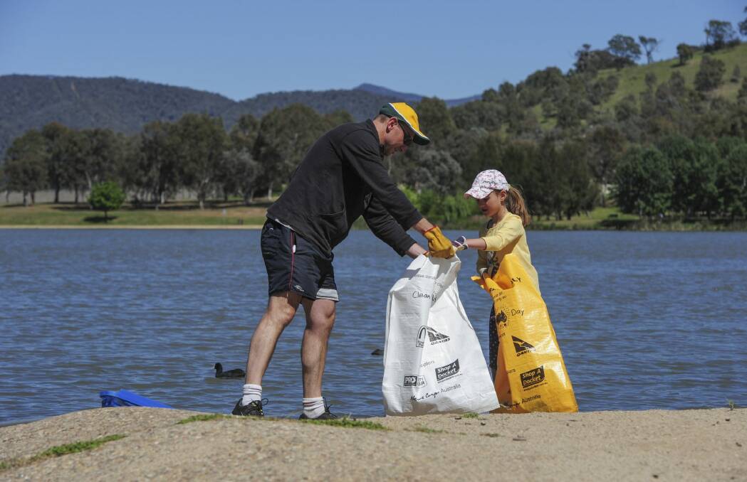 James Fletcher, of Wanniassa, and his  daughter, Emma, 6, collect rubbish at the lake.  Photo: Graham Tidy