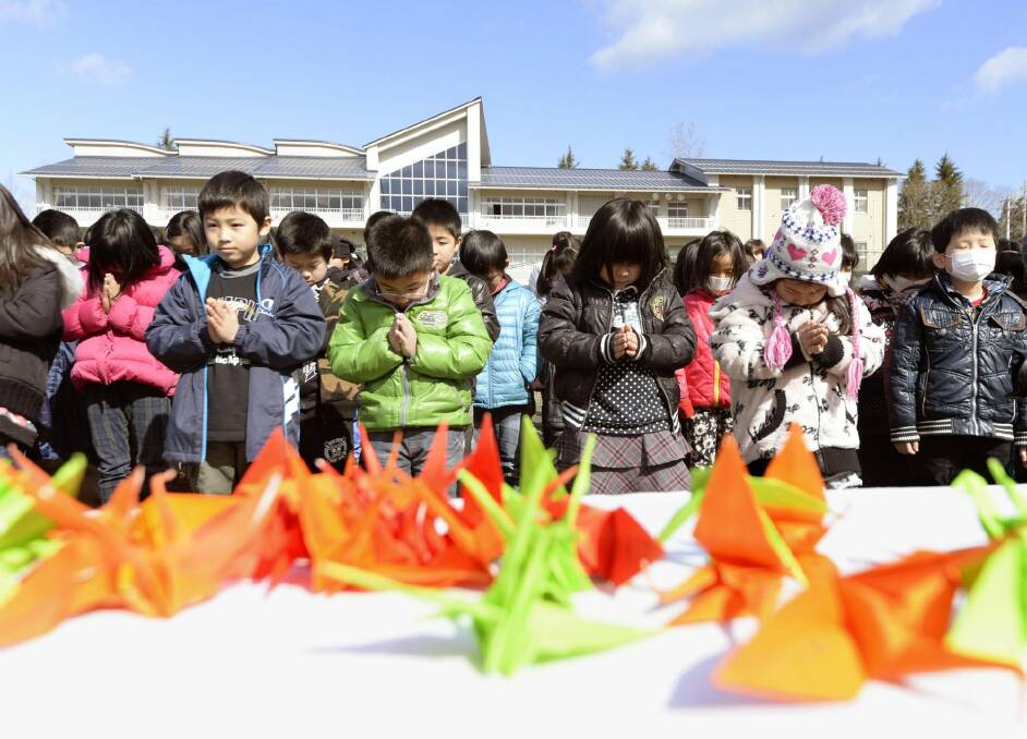 Students of an elementary school pray for victims of the March 11, 2011 earthquake and tsunami in Japan.
 Photo: AP