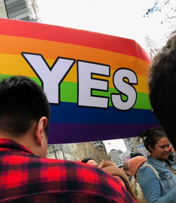 A rainbow-coloured 'Yes' flag flies at the Equal Love Rally in Melbourne's CBD. Photo: Tom McKendrick