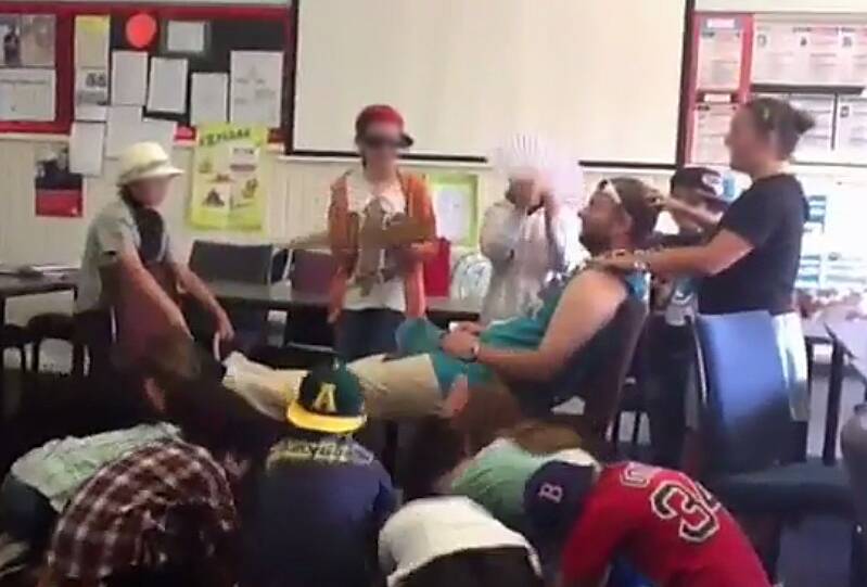 A still from a video in which students massage former Caulfield Junior College teacher Chris Adams and bow to him Photo: Supplied