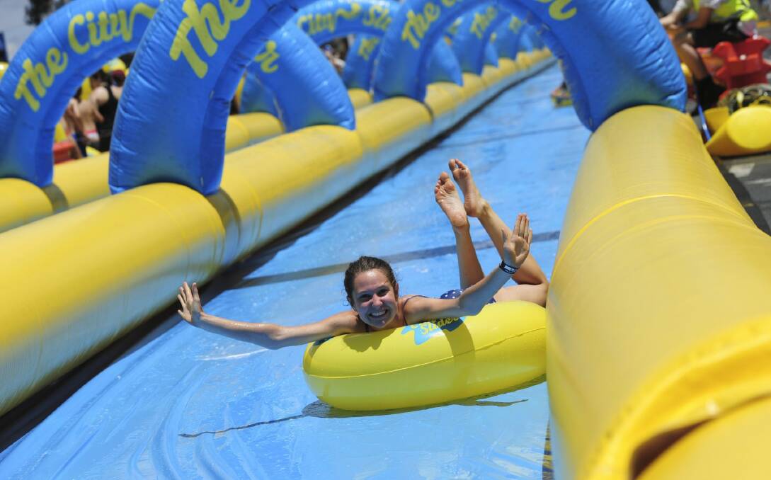 The City Slider, a 325 metre long water slide set up on Cohen Street, Belconnen, was a hit with the thousands of people that used it in the 30 degree heat. Photo: Graham Tidy